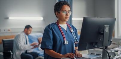 Female doctor looks at healthcare charts on a computer